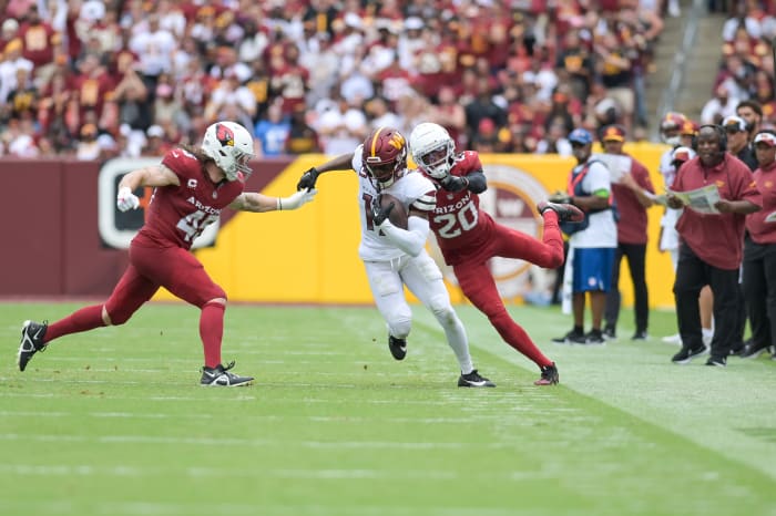 Washington Commanders wide receiver Terry McLaurin (17) cuts in-between Arizona Cardinals linebacker Dennis Gardeck (45) and cornerback Marco Wilson (20) as assistant head coach/offensive coordinator Eric Bieniemy look on during the first half at FedExField.